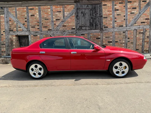 A red Alfa Romeo 166 in profile