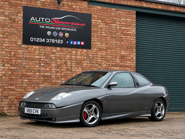 A silver Fiat Coupe parked outside the workshop